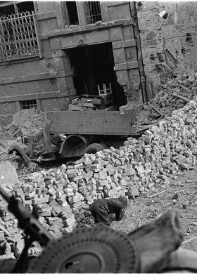 Powstaniec czołgający się pod osłoną przez ulicę Warecką