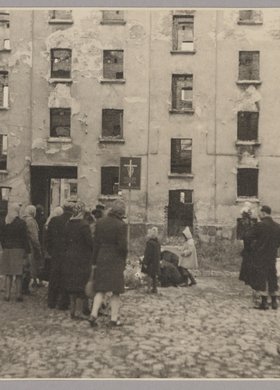 Mieszkańcy podczas święta zmarłych w miejscu egzekucji na podwórzu kamienicy przy ulicy Wolskiej 102