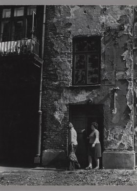 Dwie kobiety wychodzące z klatki schodowej kamienicy przy ulicy Siedleckiej 27
