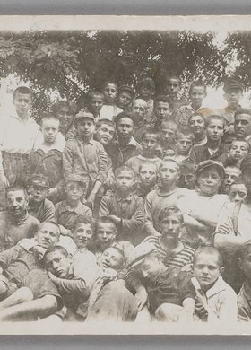 Fotografia przedstawiająca Janusza Korczaka (Henryka Goldszmita) w otoczeniu dzieci w filii Domu Sierot Różyczka (Gocławek)