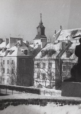 Pomnik Syreny na murach obronnych zimą; w tle kamienice przy ulicy Mostowej