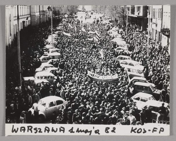 Fotografia czarnobiała przedstawiająca marsz członków NSZZ 'Solidarność' ulicami Warszawy w dniu 1 maja 1982 r. niosących flagi i transparenty, 1 maj 1982