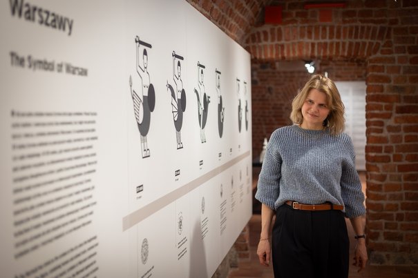 Anna Światłowska w sali wystawy prezentującej ewolucję warszawskiej syreny