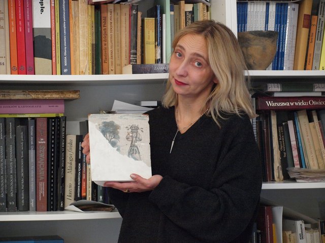 Ewelina Więcek-Bonowska trzymająca kaflel piecowy