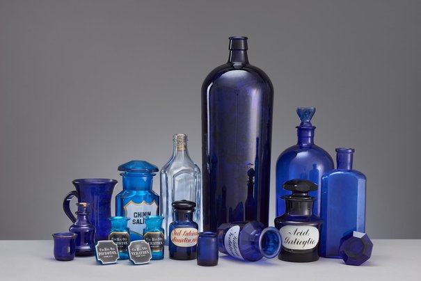 Zdjęcie kompilacyjne przedstawiające butelki po lekach wykonane z niebieskiego szkła